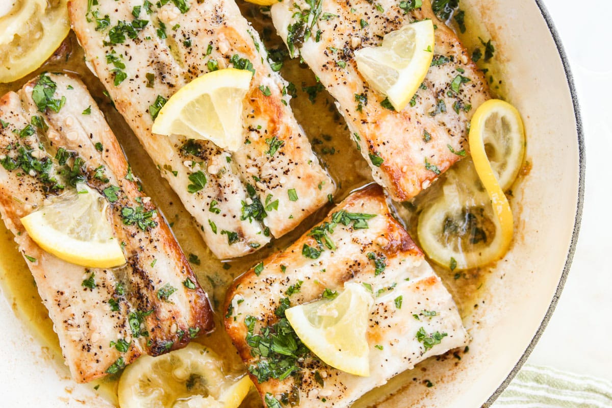 up close shot of mahi mahi in lemon butter sauce in a skillet