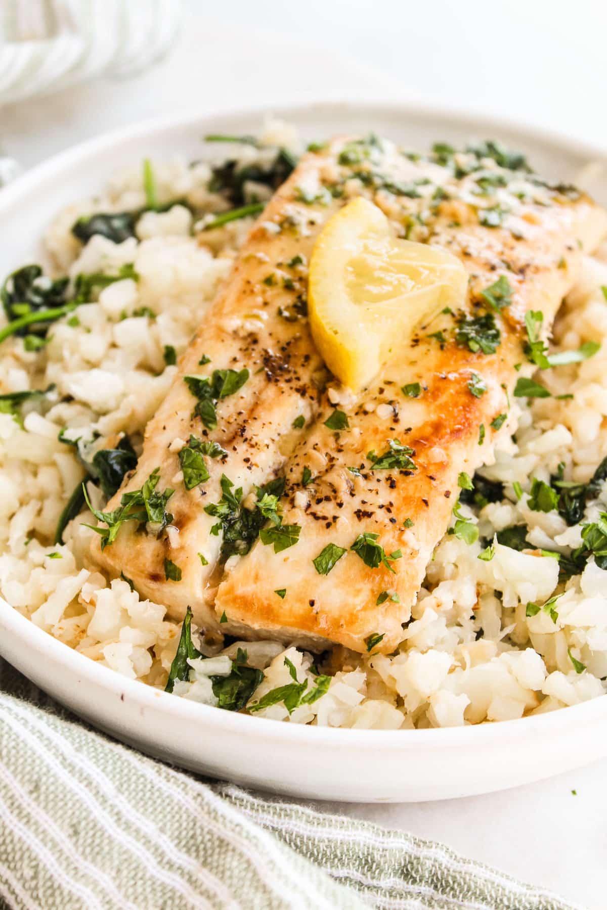 up close shot of mahi mahi on cauliflower rice in a bowl